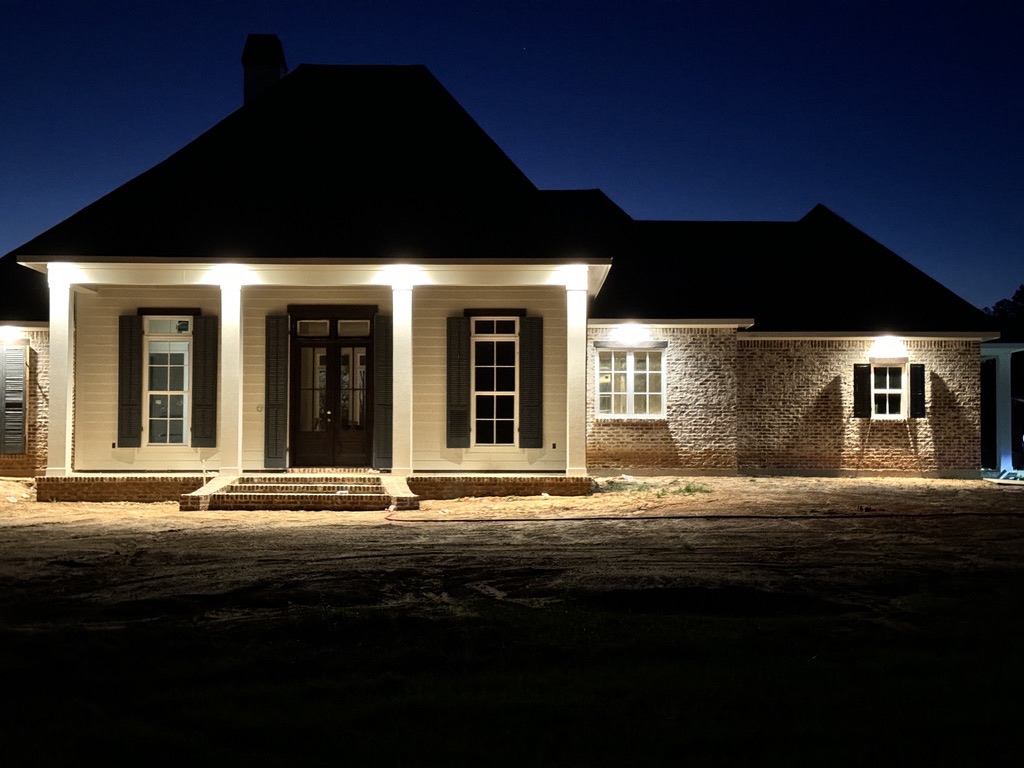 Front porch and brick exterior illuminated at night